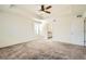 Main bedroom showcasing a tray ceiling, plush carpeting, and ensuite access at 9544 Pitkin St, Commerce City, CO 80022