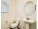 Stylish powder room with pedestal sink, oval mirror, and modern fixtures at 9544 Pitkin St, Commerce City, CO 80022