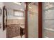 Modern bathroom with granite vanity top, mosaic tile accents, and glass block window for natural light at 6043 S Cody Way, Littleton, CO 80123
