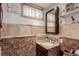 Updated bathroom with granite vanity top, stylish mirror, and a charming accent shelf at 6043 S Cody Way, Littleton, CO 80123