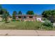 Charming single-story home with a well-manicured lawn, beautiful flowerbeds, and a brick facade at 6043 S Cody Way, Littleton, CO 80123