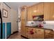 Kitchen with wood cabinets, brick tile backsplash and matching floors at 6043 S Cody Way, Littleton, CO 80123