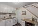 Cozy kitchen featuring white cabinets, granite countertops, and stairs nearby at 6043 S Cody Way, Littleton, CO 80123