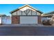 Exterior view of a two-car garage with a brick facade and landscaped surroundings at 8645 Coors St, Arvada, CO 80005