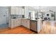 Bright open kitchen featuring white cabinetry, quartz countertops, stainless appliances, and eat-in bar at 8645 Coors St, Arvada, CO 80005