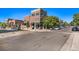 Street view of brick building with commercial space and apartments above near mature trees at 8645 Coors St, Arvada, CO 80005