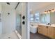 Bathroom featuring a soaking tub, walk-in shower with glass door, and modern vanity at 1875 Hickory Ave, Erie, CO 80516
