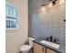 Modern half-bathroom with patterned tile wall and contemporary vanity with undermount sink at 1875 Hickory Ave, Erie, CO 80516