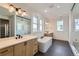 Luxurious bathroom with dual sinks, soaking tub, walk-in shower, and modern fixtures at 1875 Hickory Ave, Erie, CO 80516