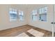 Bright bedroom with three windows, hardwood floors and white trim at 1875 Hickory Ave, Erie, CO 80516