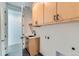 Well-lit laundry room with wood cabinets and modern fixtures at 1875 Hickory Ave, Erie, CO 80516