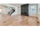 Open-concept living room featuring a modern fireplace, abundant natural light, and sleek hardwood floors at 1875 Hickory Ave, Erie, CO 80516