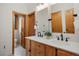 Bright bathroom with double sinks, white countertops, wood cabinets, and a view to the toilet at 858 Swandyke Dr, Castle Rock, CO 80108