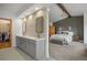 Luxurious bathroom featuring dual vanities, a stone accent wall, and access to the main bedroom at 858 Swandyke Dr, Castle Rock, CO 80108