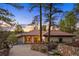 Charming single-story home with a tile roof, mature trees, and lush landscaping at 858 Swandyke Dr, Castle Rock, CO 80108