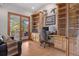 Inviting home office features custom built-ins, hardwood floors, and sliding glass doors to the outdoor balcony at 858 Swandyke Dr, Castle Rock, CO 80108