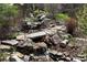 Beautiful water feature with cascading waterfalls and lush greenery enhancing the serene backyard landscape at 858 Swandyke Dr, Castle Rock, CO 80108