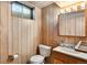 Cozy bathroom with wood paneling, vanity with sink, and updated fixtures at 6506 Lee St, Arvada, CO 80004