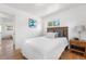 Bright bedroom with hardwood floors, a wooden headboard, a window, and a view to a connected room at 6506 Lee St, Arvada, CO 80004