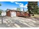 Brick ranch-style home boasts an attached garage and cozy front porch, perfect for enjoying the outdoors at 6506 Lee St, Arvada, CO 80004