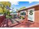 Charming front porch with red wood and brick exterior features a welcome mat and lovely seasonal wreath at 6506 Lee St, Arvada, CO 80004
