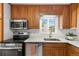 The kitchen has stainless steel appliances, wooden cabinets and updated fixtures at 6506 Lee St, Arvada, CO 80004