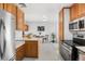 Updated kitchen with stainless steel appliances, wooden cabinets, and view into the dining area at 6506 Lee St, Arvada, CO 80004