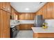 Modern kitchen with wooden cabinets and updated stainless steel appliances at 6506 Lee St, Arvada, CO 80004