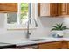 Well-lit kitchen sink area featuring stone countertops, a modern faucet, and a view from the window at 6506 Lee St, Arvada, CO 80004