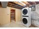 Basement laundry room featuring stacked washer/dryer and convenient shelving at 6506 Lee St, Arvada, CO 80004