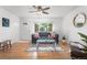 Bright living room features hardwood floors, a ceiling fan and lots of natural light from the large window at 6506 Lee St, Arvada, CO 80004
