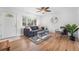Bright living room features hardwood floors, a ceiling fan and lots of natural light from the large window at 6506 Lee St, Arvada, CO 80004