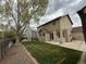 Landscaped backyard with a lush lawn, mature trees, and a concrete patio area perfect for outdoor entertaining at 13031 Dexter St, Thornton, CO 80241