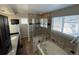 Bathroom with a jacuzzi, granite countertops, and a glass-enclosed shower at 13031 Dexter St, Thornton, CO 80241