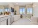 Elegant bathroom featuring a soaking tub, separate shower, vanity with storage, and bright natural light at 13940 Hanging Lake St, Parker, CO 80138