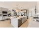 Bright, modern kitchen features an oversized island, stainless steel appliances, and flows into an open-concept living area at 13940 Hanging Lake St, Parker, CO 80138