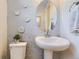 Stylish powder room featuring a pedestal sink, modern decor, and a unique oval mirror at 13940 Hanging Lake St, Parker, CO 80138