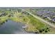 Picturesque view of a pond with a dock, bordered by open fields and a highway at 14447 Madison St, Thornton, CO 80602