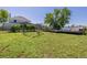 Expansive backyard with mature tree, wooden deck, playground, and white fence, perfect for outdoor enjoyment at 14447 Madison St, Thornton, CO 80602