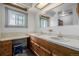 Double sink bathroom featuring warm lighting, wood cabinetry, a window and framed mirrors at 14447 Madison St, Thornton, CO 80602