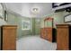 This bedroom has green walls, a large window with outdoor views, and hardwood cabinets at 14447 Madison St, Thornton, CO 80602