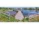 A picturesque dock extends into a calm lake, surrounded by lush greenery and a secure white fence at 14447 Madison St, Thornton, CO 80602
