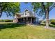 Two-story home featuring a brick facade, an attached garage, a front porch and a well-maintained lawn at 14447 Madison St, Thornton, CO 80602