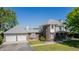 Stately brick and siding home featuring a three-car garage, well-manicured lawn, and mature trees at 14447 Madison St, Thornton, CO 80602