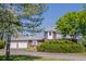 Charming two-story home featuring a brick facade, a two-car garage, and mature landscaping at 14447 Madison St, Thornton, CO 80602