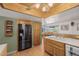 An efficient kitchen featuring wood cabinets, a refrigerator with water dispenser, and hardwood floors at 14447 Madison St, Thornton, CO 80602