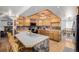 Well-lit kitchen featuring wood cabinets, a center island with seating, and stainless steel appliances at 14447 Madison St, Thornton, CO 80602