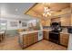 Bright kitchen with wooden cabinets and flooring, island with seating and stainless steel appliances at 14447 Madison St, Thornton, CO 80602