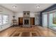 Cozy living room featuring a brick fireplace, built-in shelving, and hardwood floors at 14447 Madison St, Thornton, CO 80602