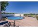An inviting above-ground pool surrounded by a wooden deck and white fence under a clear sky at 14447 Madison St, Thornton, CO 80602